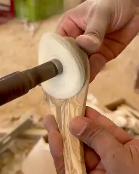 Une cuillère en bois d’olivier polie à la main sur une roue de polissage